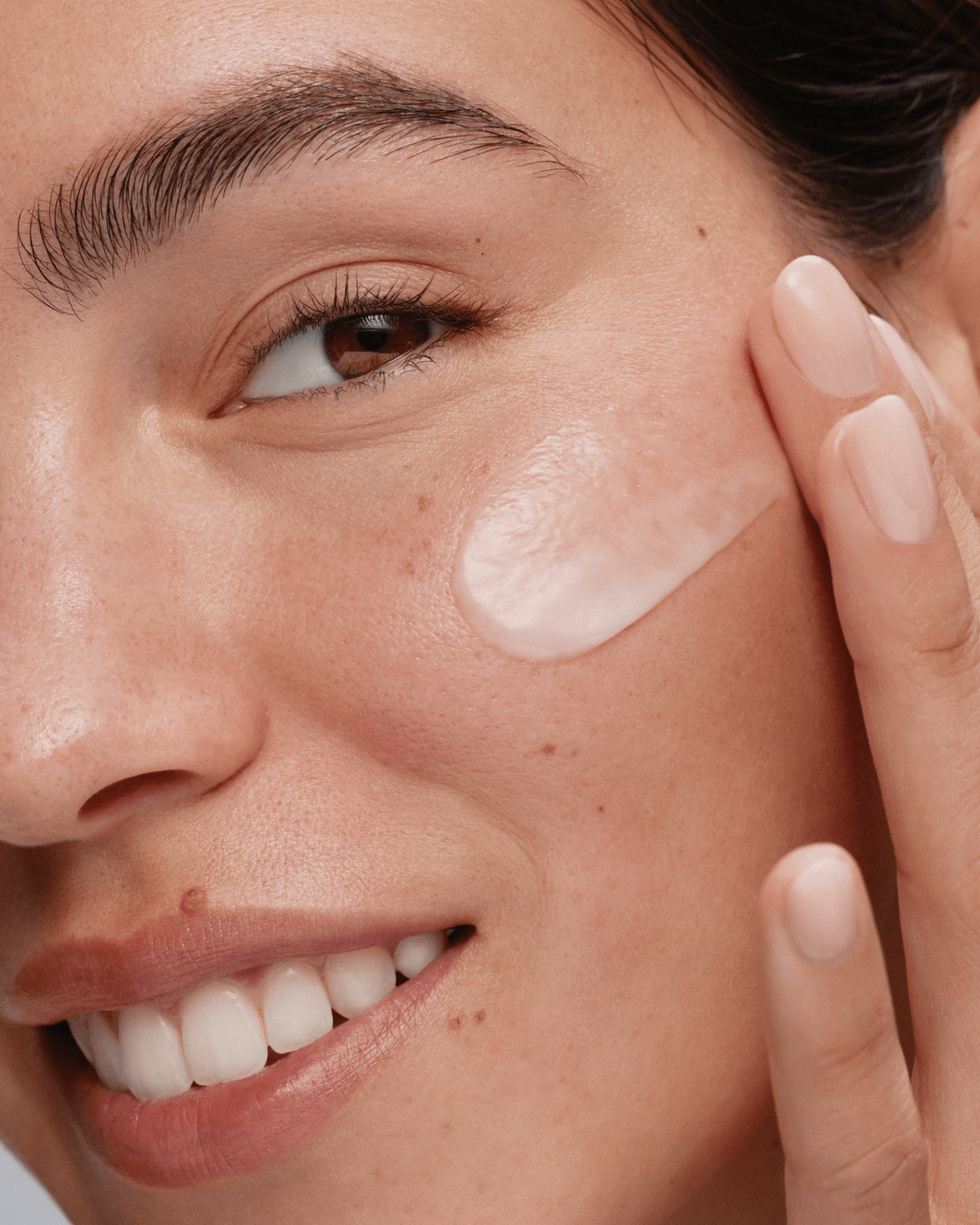 A person applying Skinfix Barrier Balancing Water Cream to their cheek