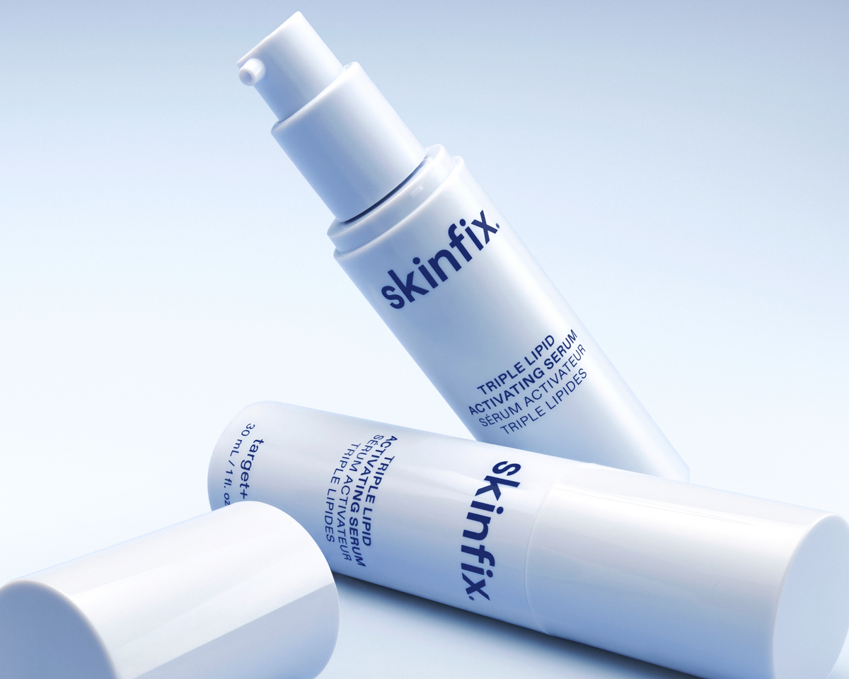 Three white skincare pump bottles from the brand skinfix, including Triple Lipid Activating Serum and Triple Lipid Serum, arranged on a clean light blue gradient background.