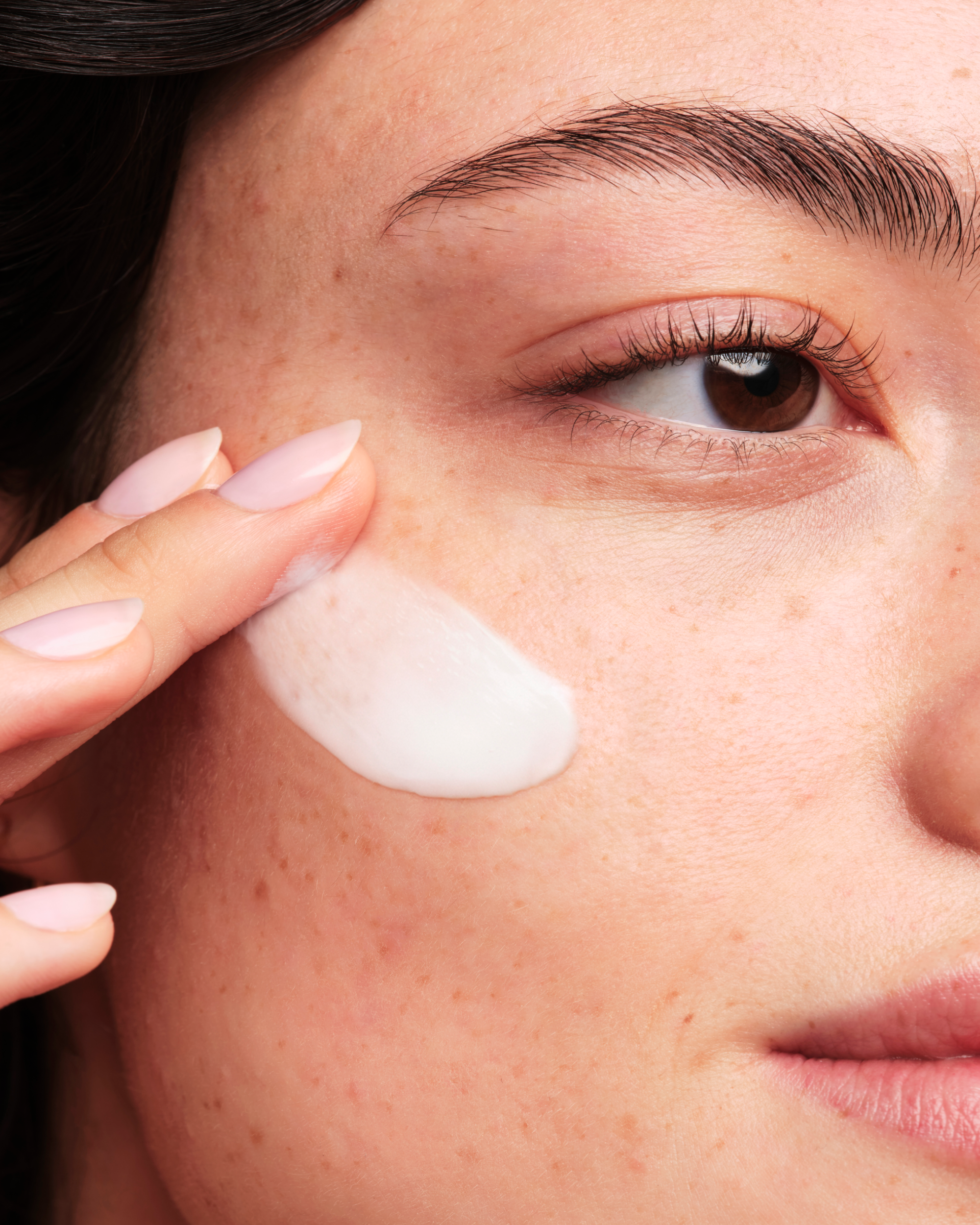 A person applying Skinfix Triple Lipid-Peptide Cream to their cheek